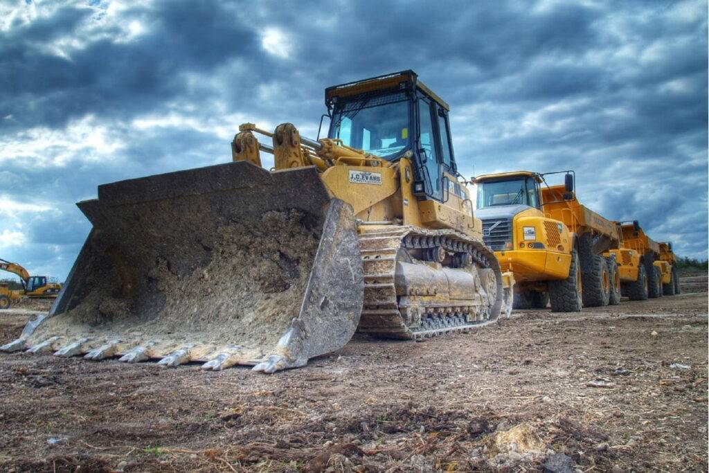 Heavy Equipment Glossary Buying used heavy equipment vs new - front end loader and dump truck on site