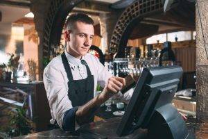 waiter working at POS terminal in a Restaurant Business